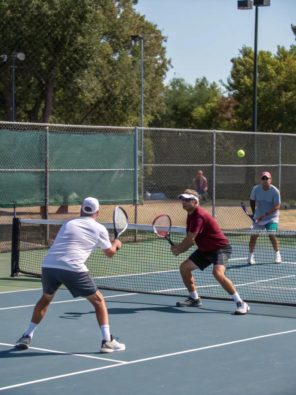 An action shot of adults engaged in a friendly doubles match, capturing the spirit of recreational play and camaraderie at the K&A TENNIS CLUB.
